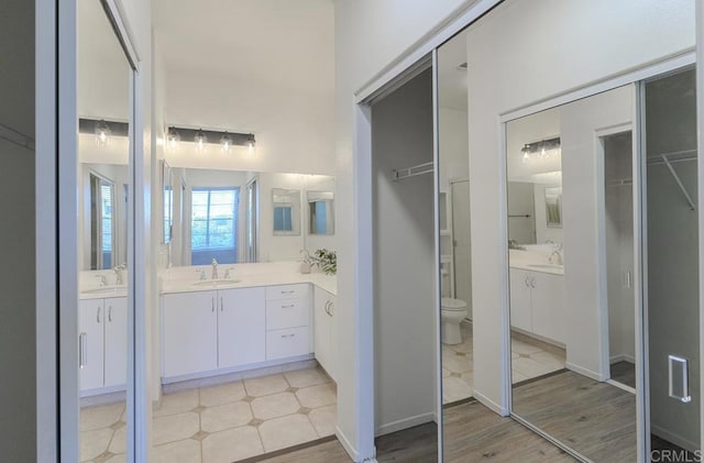 bathroom featuring vanity, wood-type flooring, and toilet