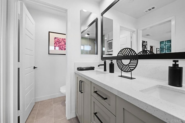 bathroom featuring vanity, tile patterned floors, and toilet