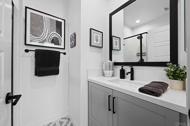 bathroom featuring a shower with door and vanity