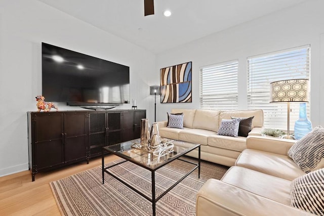 living room featuring ceiling fan and light hardwood / wood-style floors