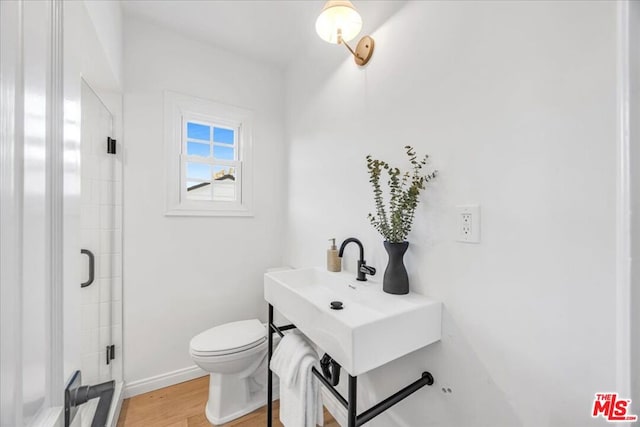 bathroom featuring walk in shower, toilet, and hardwood / wood-style floors