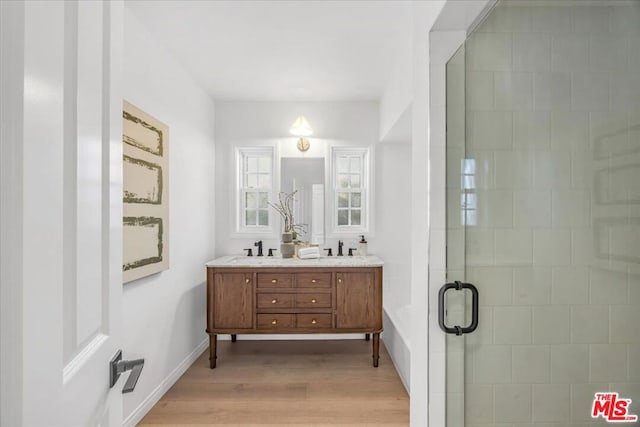 bathroom with vanity, wood-type flooring, and walk in shower