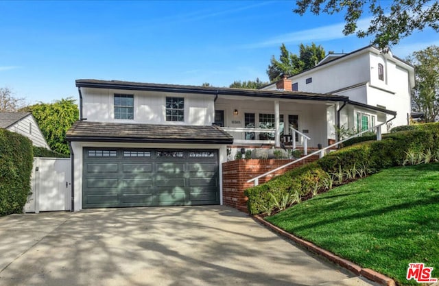 front of property with a porch, a garage, and a front yard