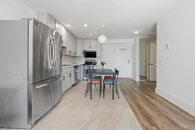 kitchen featuring stainless steel appliances and hanging light fixtures