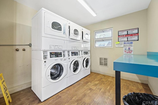 washroom featuring independent washer and dryer, stacked washing maching and dryer, and light hardwood / wood-style floors