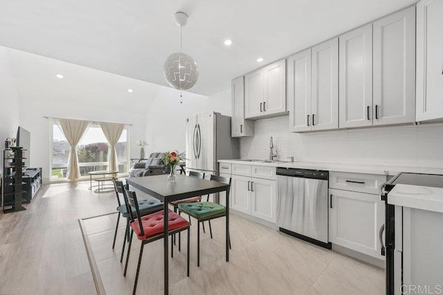 kitchen with stainless steel appliances, decorative light fixtures, sink, and white cabinets