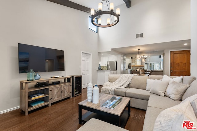 living room with dark wood-type flooring, beamed ceiling, beverage cooler, and a notable chandelier