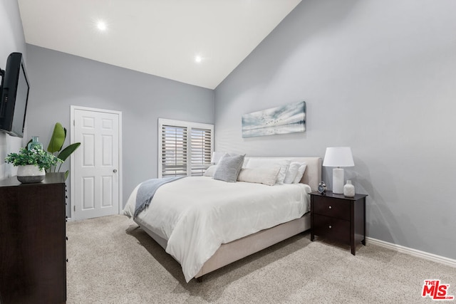 carpeted bedroom featuring high vaulted ceiling