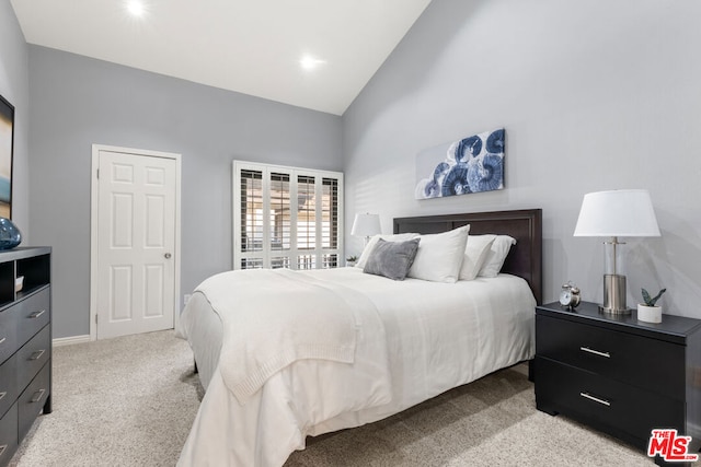 bedroom featuring light carpet and high vaulted ceiling