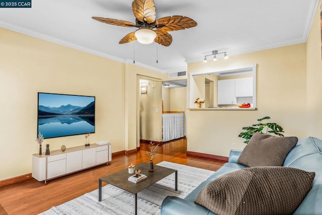 living room featuring crown molding, light hardwood / wood-style floors, and ceiling fan