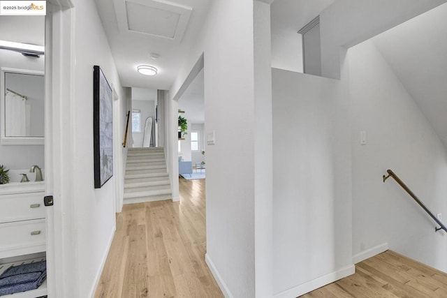 hallway with sink and light wood-type flooring