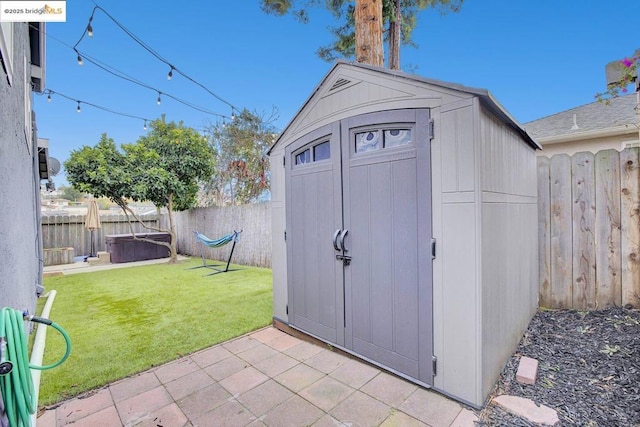 view of outbuilding with a jacuzzi and a lawn