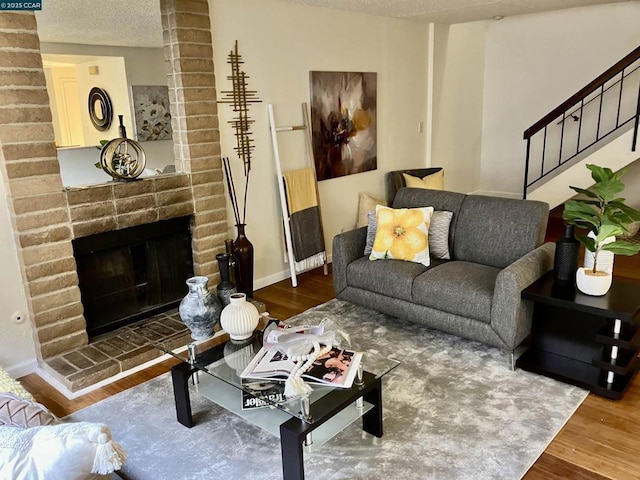 living room with dark hardwood / wood-style floors, a fireplace, and a textured ceiling