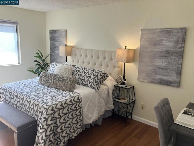 bedroom with dark hardwood / wood-style floors and a textured ceiling