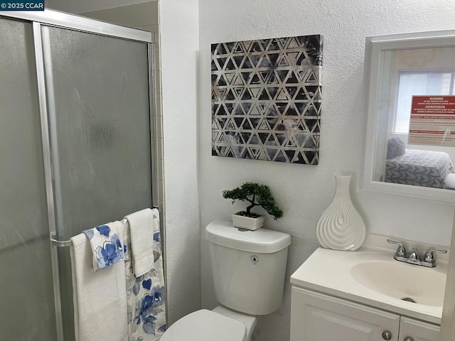 bathroom featuring vanity, toilet, and an enclosed shower