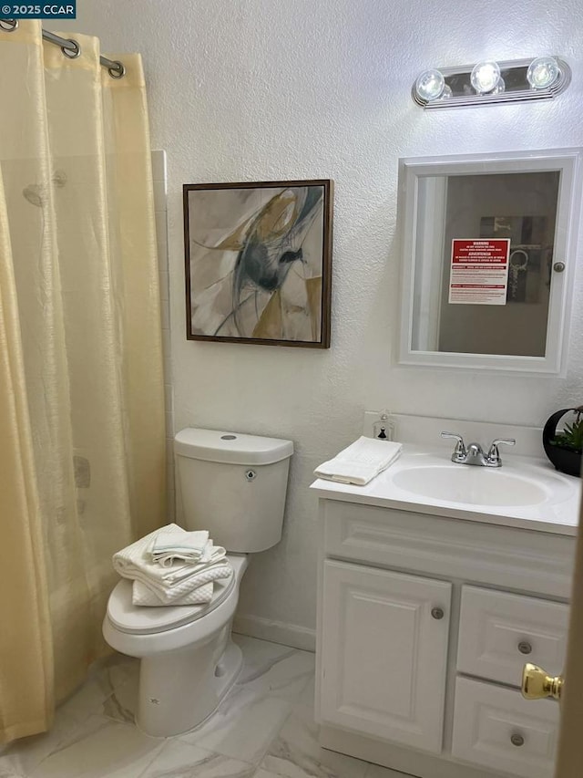 bathroom with vanity, curtained shower, and toilet