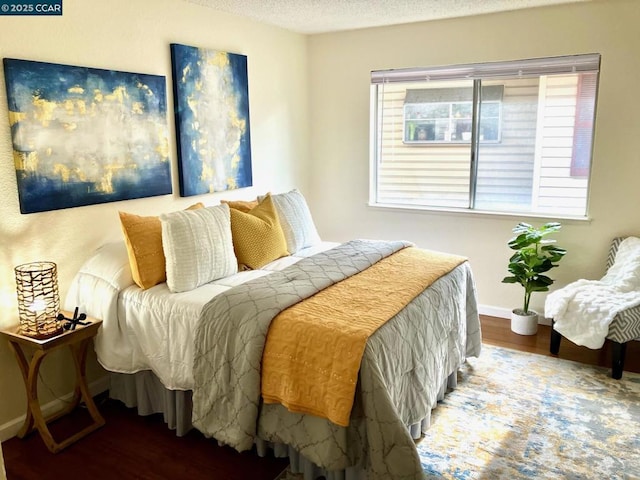 bedroom with hardwood / wood-style floors and a textured ceiling