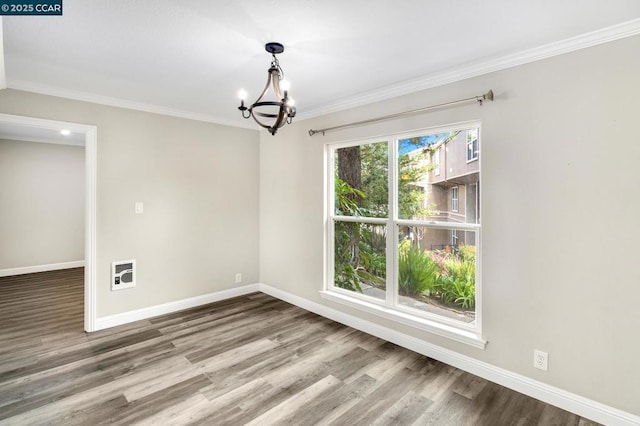 unfurnished room with ornamental molding, wood-type flooring, heating unit, and a notable chandelier