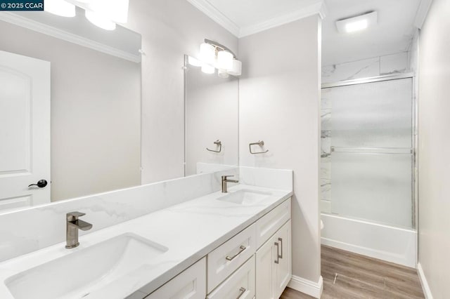 bathroom featuring vanity, hardwood / wood-style flooring, ornamental molding, and enclosed tub / shower combo