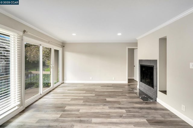 unfurnished living room featuring ornamental molding, light wood-type flooring, and a fireplace