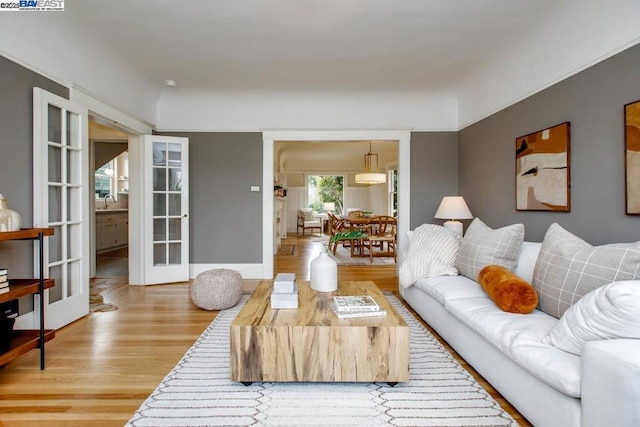 living room featuring french doors, wood-type flooring, and sink