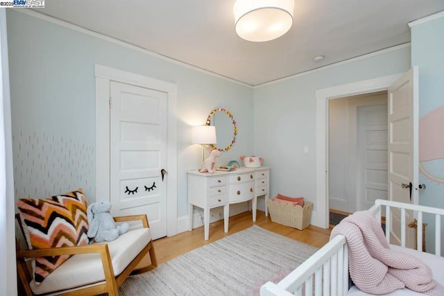 bedroom featuring ornamental molding and light hardwood / wood-style flooring