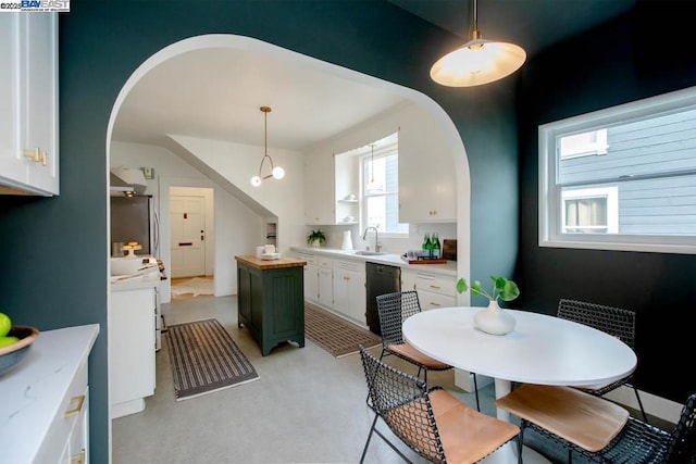 kitchen with white cabinetry, sink, decorative light fixtures, and black dishwasher