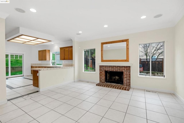 unfurnished living room with a fireplace and light tile patterned flooring