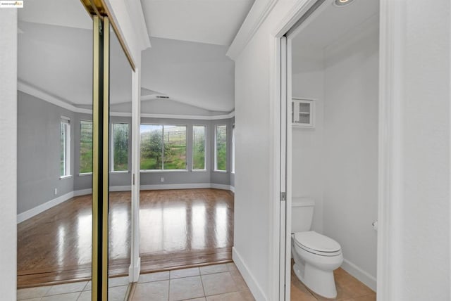 bathroom with lofted ceiling, tile patterned floors, and toilet