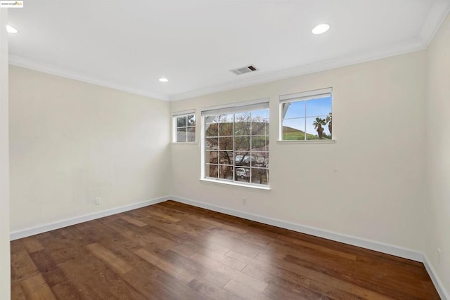 spare room featuring crown molding, a wealth of natural light, and dark hardwood / wood-style floors