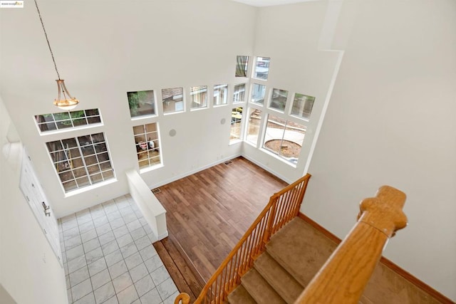 staircase featuring hardwood / wood-style floors and a high ceiling