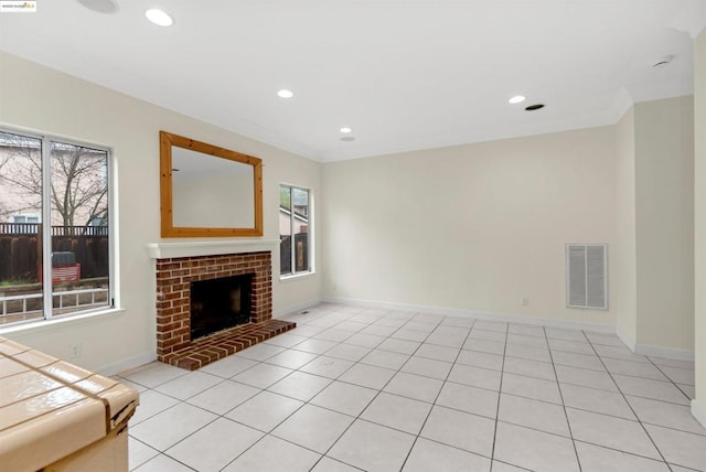 unfurnished living room with light tile patterned flooring, ornamental molding, and a fireplace