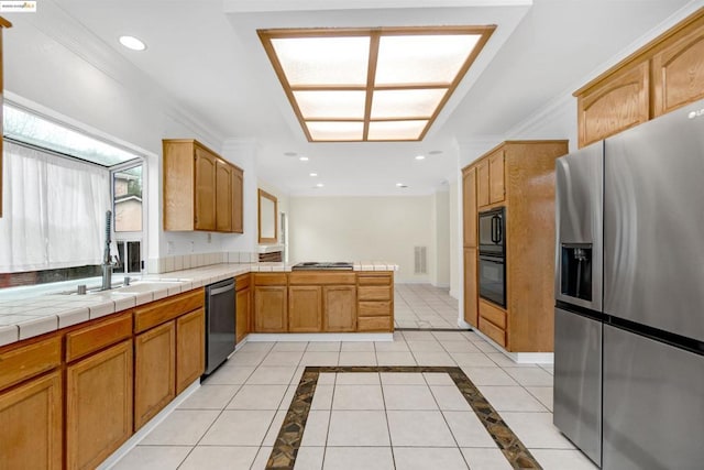 kitchen featuring tile countertops, black appliances, ornamental molding, light tile patterned floors, and kitchen peninsula