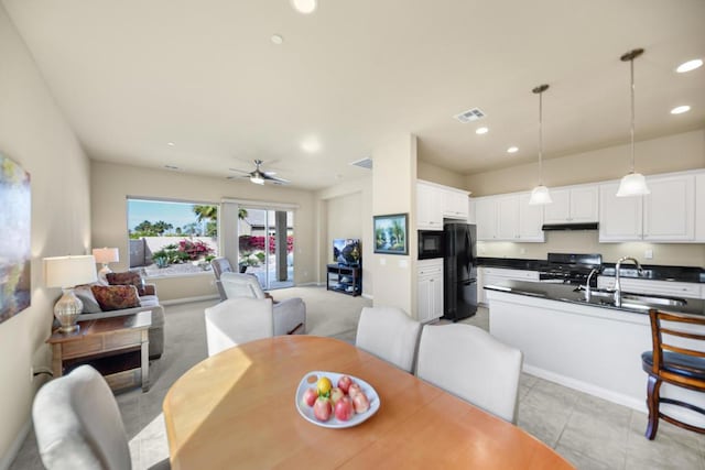 dining area featuring sink, ceiling fan, and light tile patterned flooring