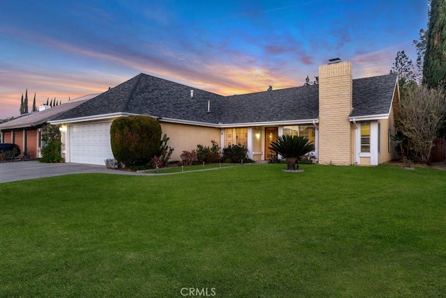 single story home featuring a yard and a garage