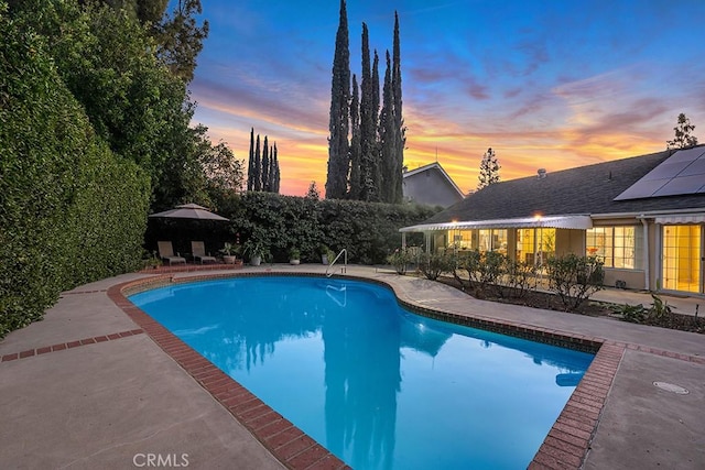 pool at dusk with a patio