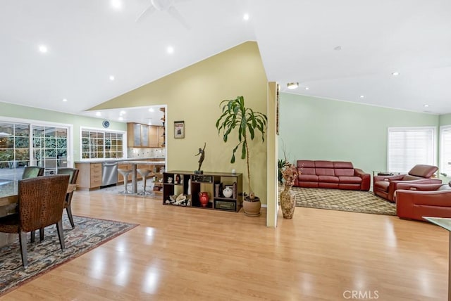 living room featuring high vaulted ceiling, ceiling fan, and light wood-type flooring