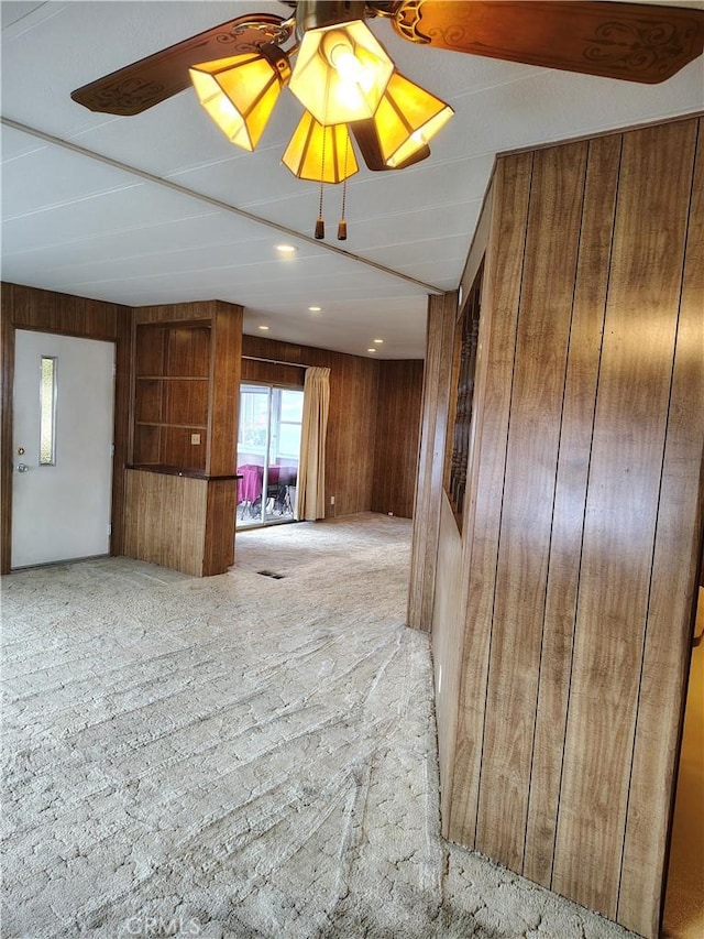 empty room featuring wood walls, a ceiling fan, and recessed lighting