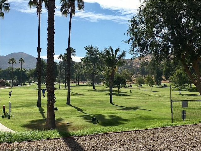 view of home's community with a yard, fence, and a mountain view