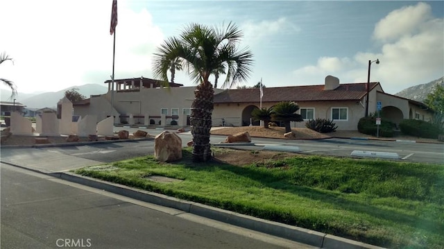 view of front facade featuring uncovered parking, a mountain view, and stucco siding