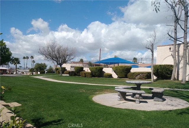 view of property's community with fence and a lawn