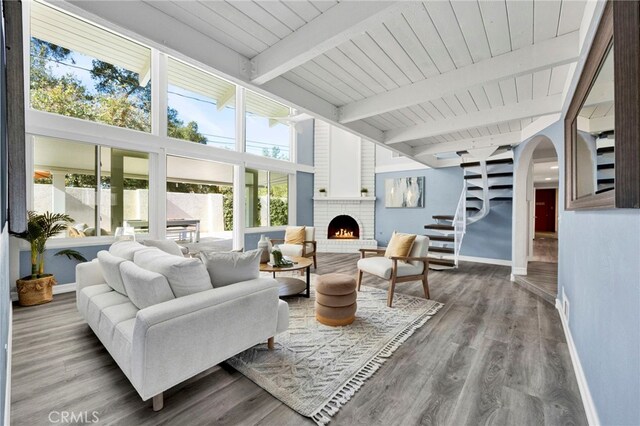 interior space featuring wood ceiling, hardwood / wood-style flooring, a fireplace, and beamed ceiling