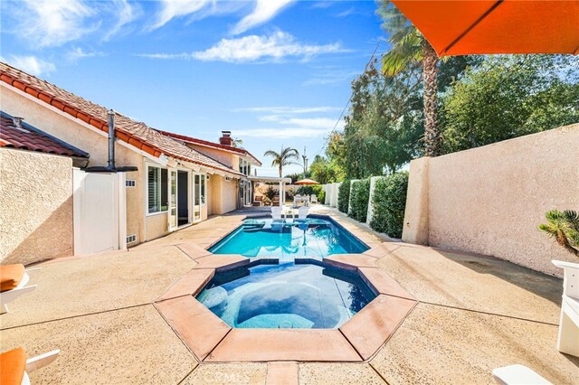 view of pool featuring an in ground hot tub and a patio area