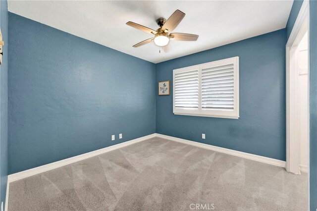 spare room featuring ceiling fan and carpet flooring