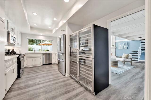 kitchen with white cabinetry, light hardwood / wood-style flooring, and appliances with stainless steel finishes