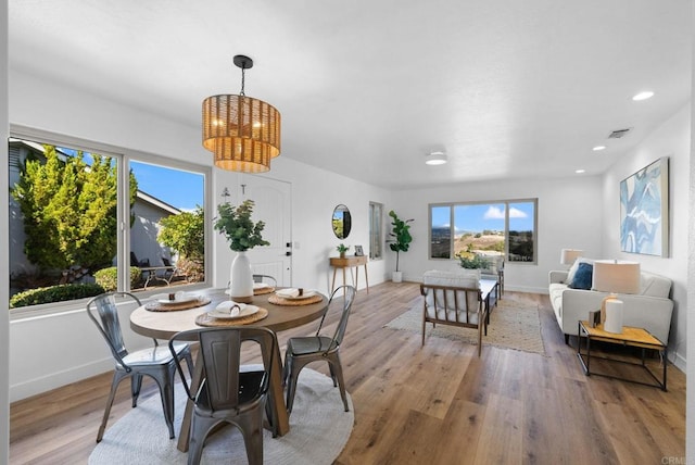 dining area with a notable chandelier and light wood-type flooring