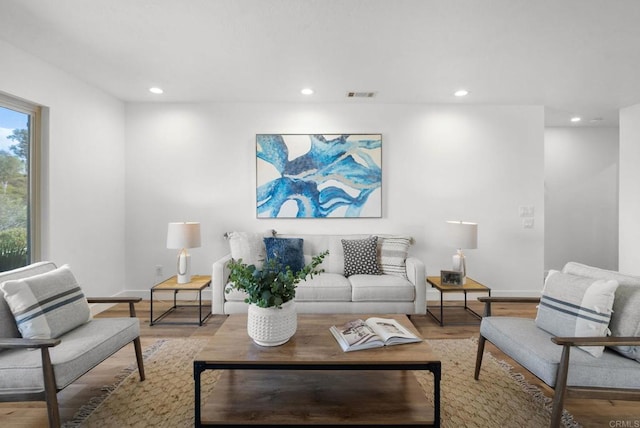 living room with light wood-style floors, baseboards, visible vents, and recessed lighting