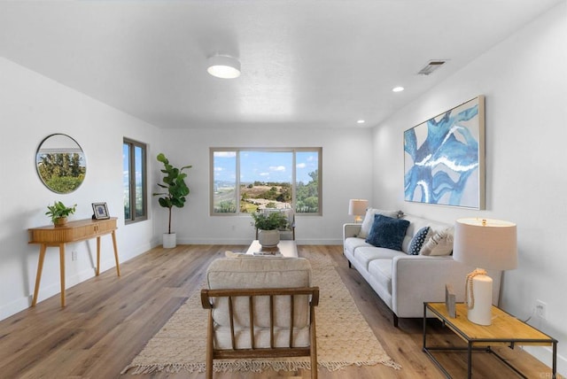 living area featuring recessed lighting, baseboards, visible vents, and light wood finished floors