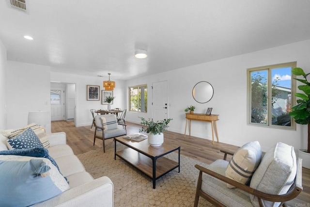 living room with light wood-type flooring, baseboards, visible vents, and recessed lighting