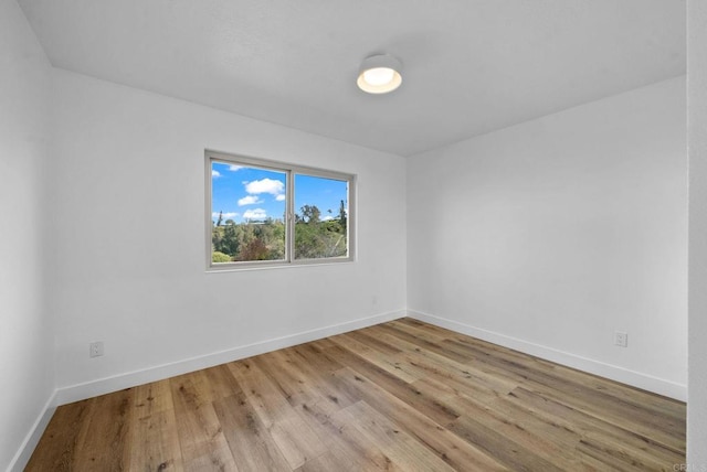 unfurnished room featuring baseboards and wood finished floors